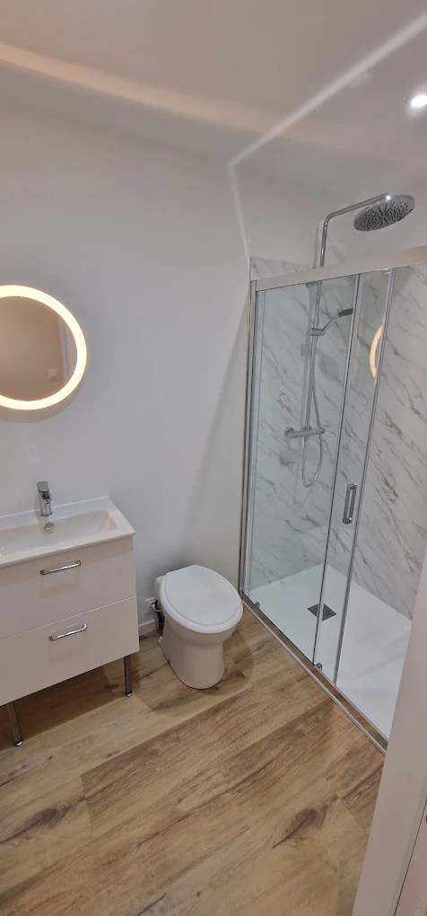 Salle d'eau blanche terminée avec douche et meuble vasque